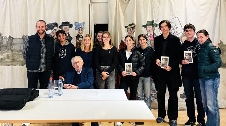 Schülerinnen, Schüler und Lehrkräfte in Dachau mit einem einem Zeitzeugen in Dachau.